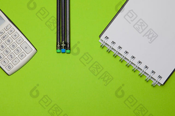 计算器记事本黑色的铅笔绿色背景前视图