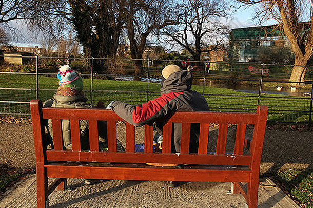 男人。女人坐着公园板凳上冬天
