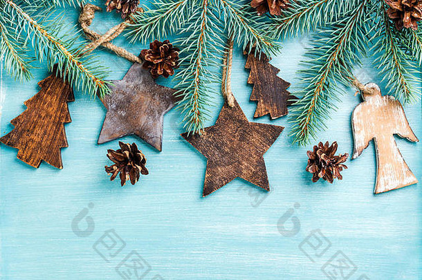 新年或圣诞节背景：木制天使、星星、小枞树、圆锥体和树枝，蓝色彩绘背景，空间