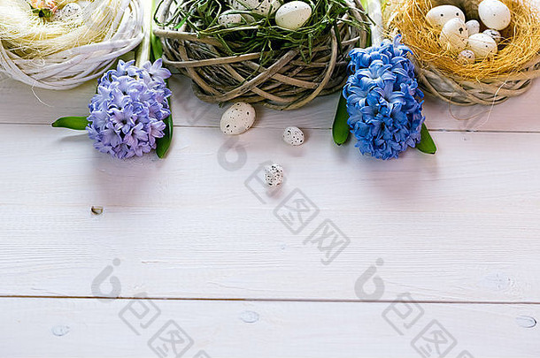 美丽的复活节背景，白色彩绘板上有花朵和蛋巢。文本的可用空间