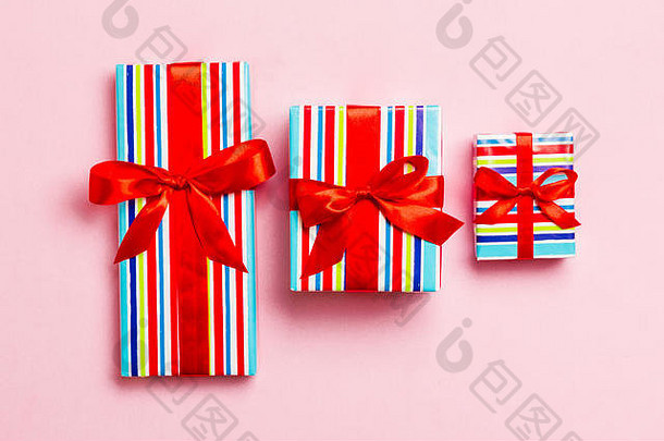 圣诞或新年礼物盒，粉红色背景，红结，俯视图。