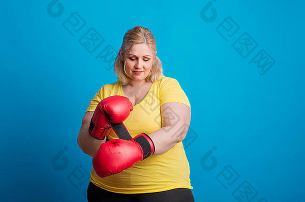 一位快乐的超重妇女在工作室戴上<strong>拳击</strong>手套的肖像。