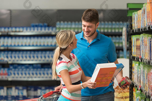 一对美丽的年轻夫妇在一家杂货店的农产品部——超市——购买早餐用的雪花