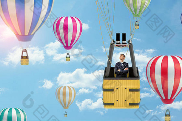 一个商人站在一个气球的篮子里，而它在天空中漂浮在许多其他气球中。