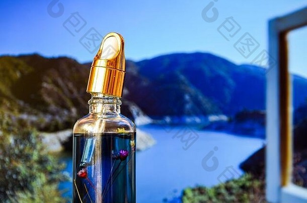 香精油滴在玻璃瓶上，从窗户看向山上的自然背景，驱虫剂，文本空间，移液管