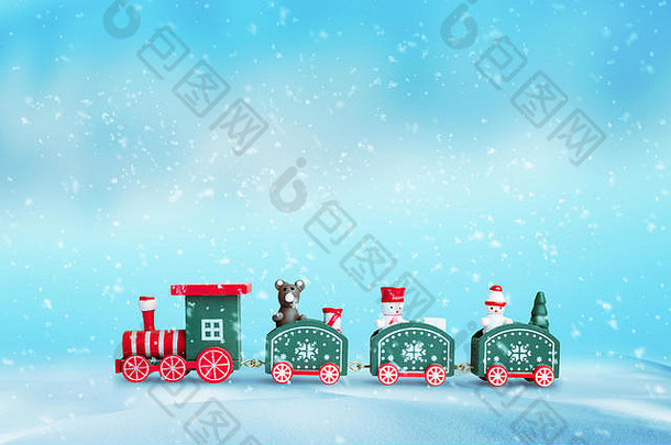 雪地里可爱的火车。圣诞节新年背景。马车上有一只熊和两只雪鞋的木制玩具。蓝色背景。
