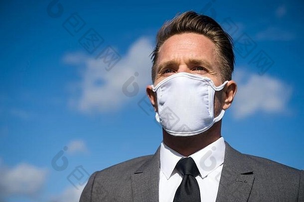 戴着外科口罩的商人站在阳光明媚的户外进行<strong>冠状病毒防护</strong>检疫