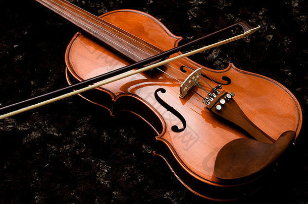 深色背景特写上的经典小提琴和蝴蝶结
