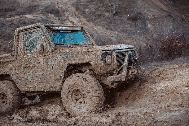 泥泞中的4x4越野吉普车。与职业司机一起在山上进行运动和活动