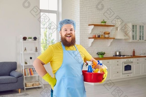 穿着围裙的快乐有趣的胖子打扫屋子。