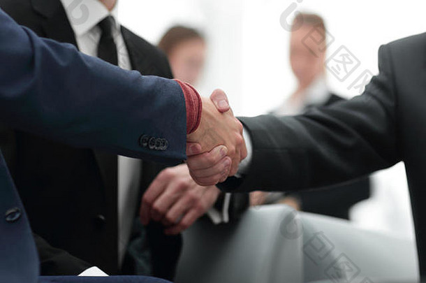 合作伙伴在<strong>团队</strong>成员面前完成交易并握手