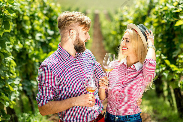 一对夫妇在葡萄园喝着葡萄酒玩得很开心
