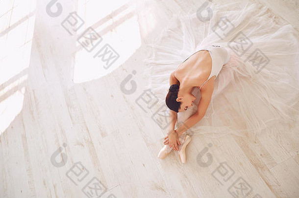 年轻的芭蕾舞演员在地板上摆姿势