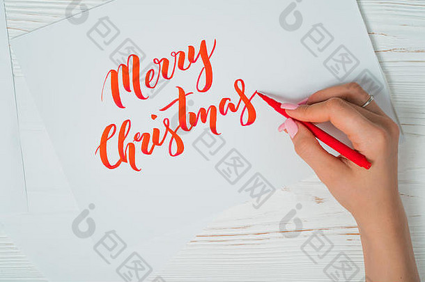 圣诞快乐，祝贺你。书法家用红墨水在白卡上写字。书法装饰字体。刻字艺术。平面设计，韩