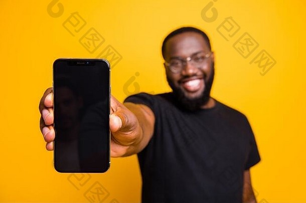 积极的非裔美国人男子肖像手持智能手机展示现代科技小玩意广告促销穿休闲风格套装隔离黄色