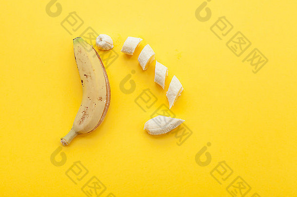 在黄色背景上剥香蕉和水果