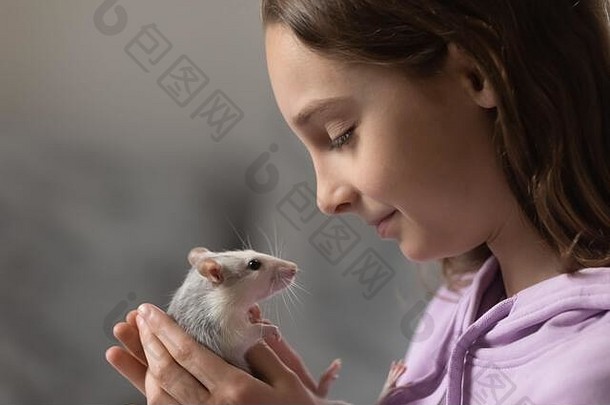 快乐的少女，手里拿着驯养的小老鼠，特写