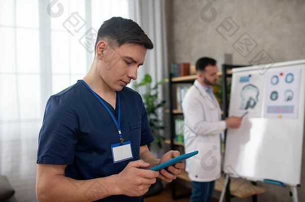黑发年轻医生在平板电脑上输入信息