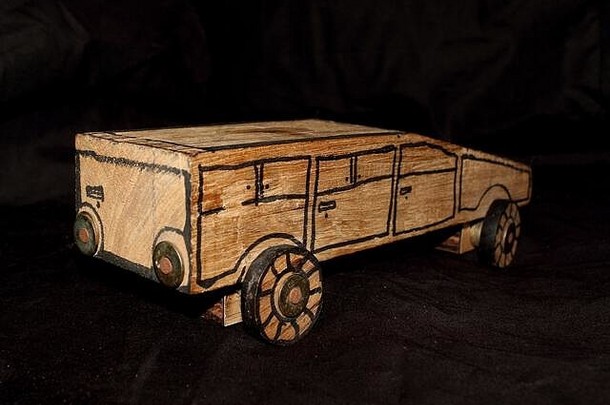 黑色背景上的儿童手工木制汽车玩具