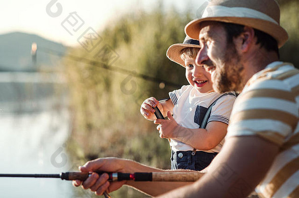 成熟的父亲小蹒跚学步的儿子在户外钓鱼湖