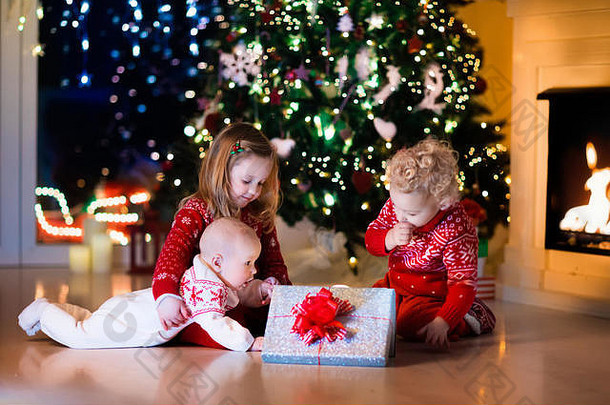 家庭圣诞节夏娃壁炉孩子们开放圣诞节礼物孩子们圣诞节树礼物盒子