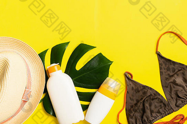 夏日沙滩配件防晒夏帽泳装亮黄色背景。暑假概念和海滩。