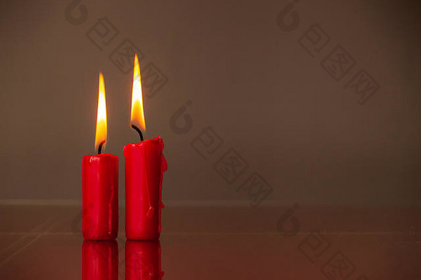 爱的概念-在温暖的背景下点燃红蜡烛