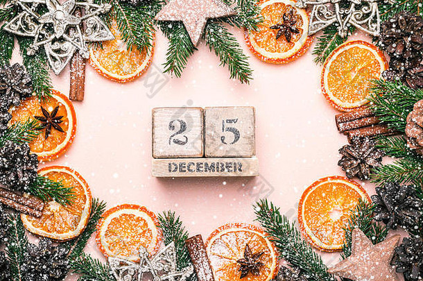 圣诞天然框架干橙子片和装饰。日历12月25日。复古色调和雪花。