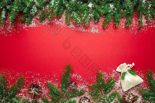 圣诞装饰和<strong>新年</strong>天然云杉树枝以红色为背景，配上礼品袋、圆锥体和雪、<strong>新年</strong>快乐概念背景