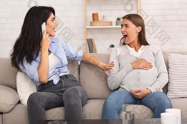 怀孕的女孩大喊大叫，她的朋友打电话给坐在沙发上的医生