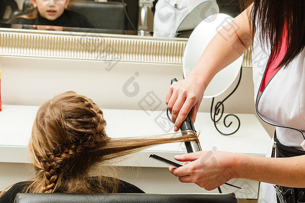儿童发型和发型概念。金发蹒跚学步的小女孩在理发店做辫子发型