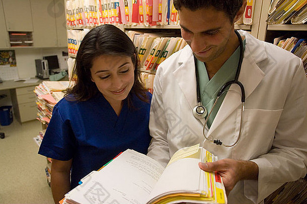年轻医生和护士翻阅医疗图表的画像