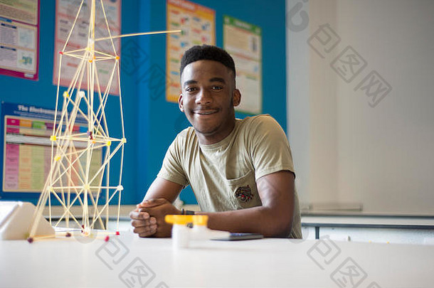 一个年轻的黑人理科学生坐在一所大学的科学实验室里，看上去很高兴