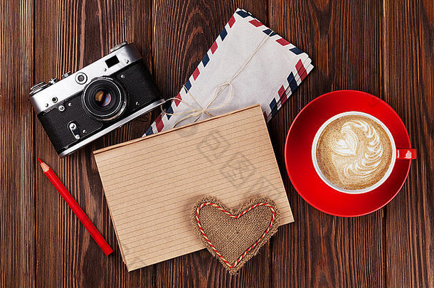 情人节玩具心，复古相机，咖啡杯和记事本为您的文字。木桌俯视图