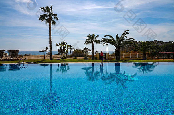 西班牙科斯塔布兰卡市蒙蒂波利城市化区帕拉伊索海滩，带人形和棕榈树<strong>的游泳</strong>池