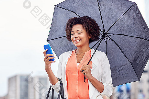 带着雨伞的女商人在智能手机上发短信