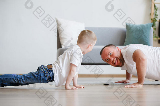 快乐的爸爸和儿子推着地板的照片