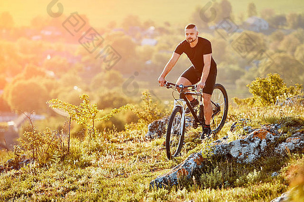 极限山地自行车手在乡村的岩石小道上骑自行车。
