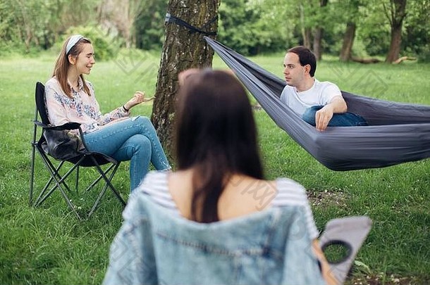 社交距离。一小群人在夏季公园野餐时享受着社交距离的交谈。新常态下的休闲活动，
