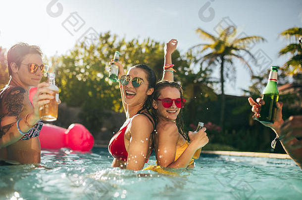 快乐朋友享受游泳池聚会，派对年轻的人游泳池喝有趣的享受假期