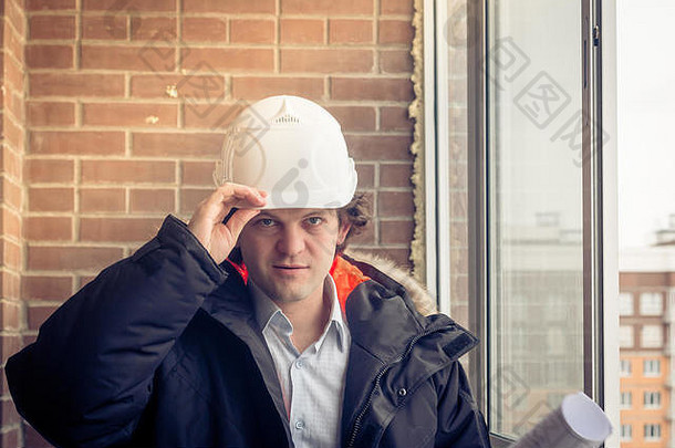 微笑业务工程师白色安全头盔持有蓝图项目计划砖建筑背景快乐商人问候手势相机软焦点健美的