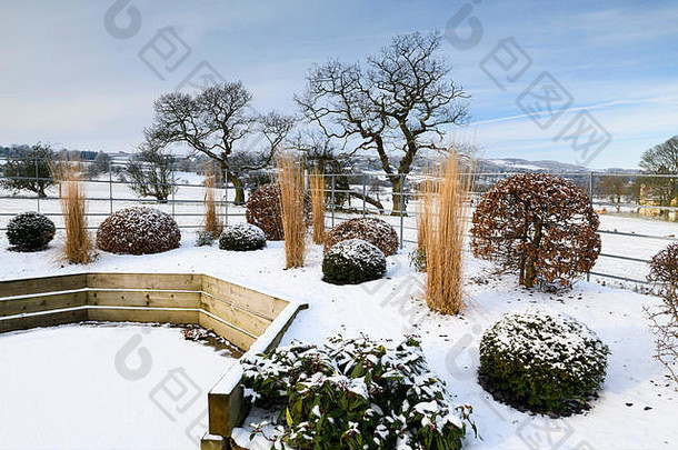 时尚、现代的设计、景观美化和在木制凸起的床上种植（露台和草地）-雪覆盖的冬季花园，英国约克郡。