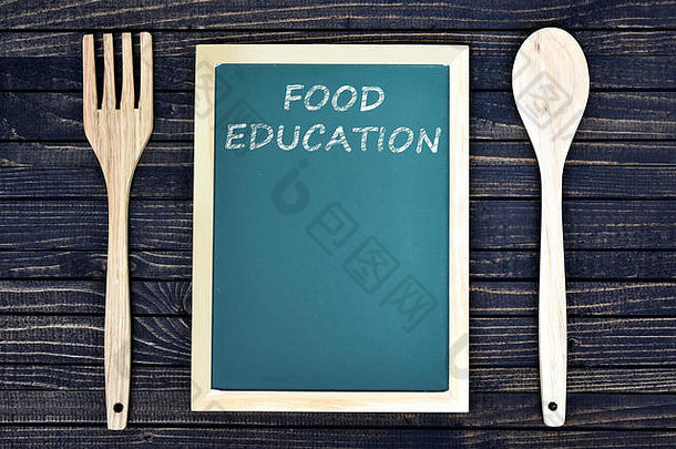 绿色木板上的食品教育文本，木桌上有叉子和勺子