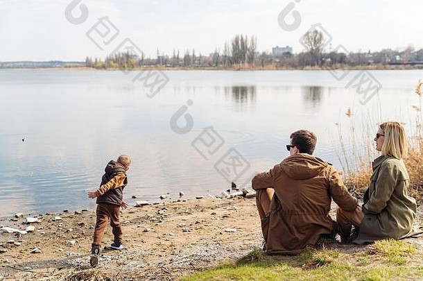 父亲教小儿子往水里扔石头