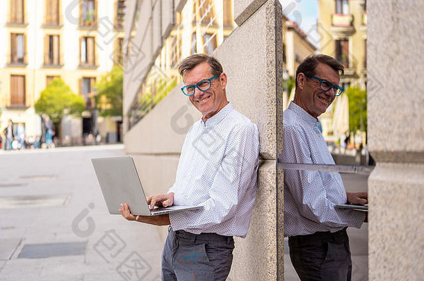时尚的老人正在使用笔记本电脑在城市户外使用现代技术在数字游牧老人家中上网保持连接和安全