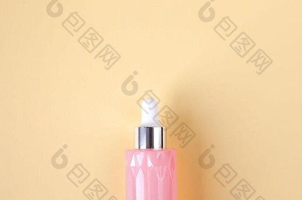<strong>粉色</strong>玻璃瓶，在柔和的黄色背景上为面部添加美容精华液，空间。顶视图。概念美容仪式，自制<strong>化妆品</strong>，皮肤护理。