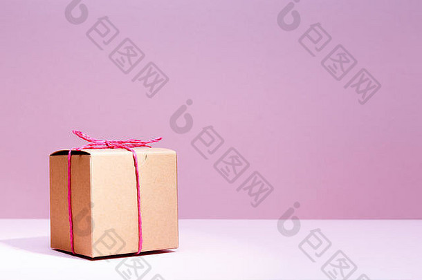 在<strong>纯色</strong>粉色<strong>背景</strong>上制作硬纸板礼品盒。节日和礼物的概念。水平的