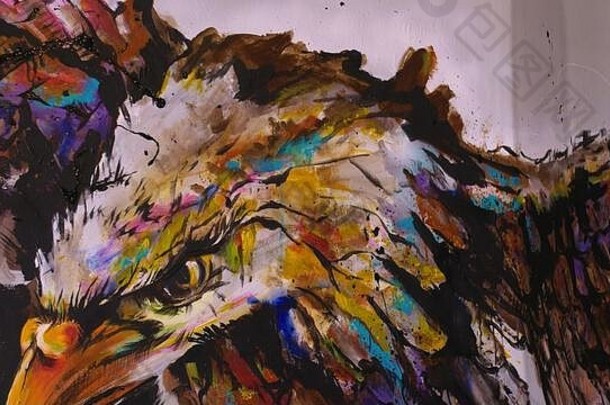 艺术家和设计师在墙上画了一只鹰。工匠-装饰师用丙烯酸油彩绘制图片。穿着油漆大衣的画家。室内的
