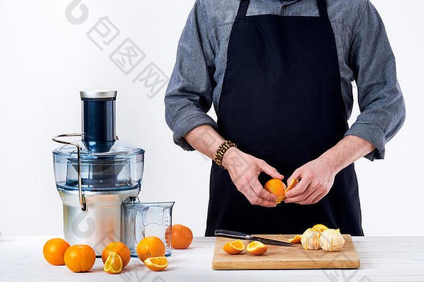匿名男人。准备新鲜的橙色汁电榨汁机健康的生活方式排毒概念白色背景一年的决议