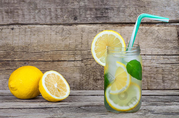 木制背景的夏季水果饮料。冰柠檬水。排毒柑橘味的水。夏日柠檬清爽鸡尾酒。